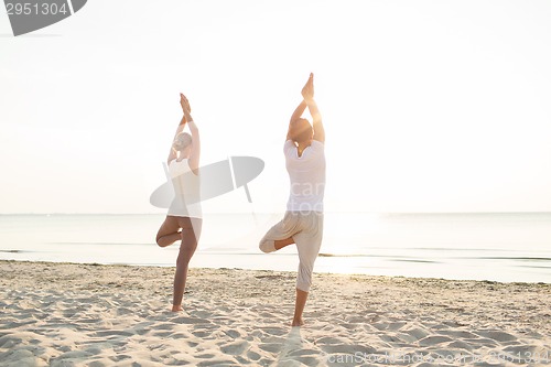Image of couple making yoga exercises outdoors from back