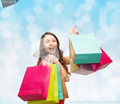 Image of smiling woman with colorful shopping bags