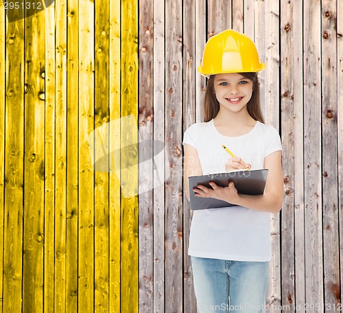 Image of smiling little girl in hardhat with clipboard