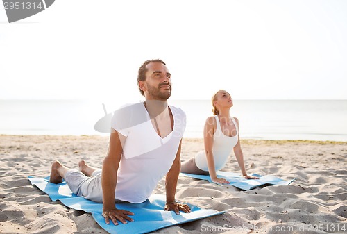 Image of couple making yoga exercises outdoors