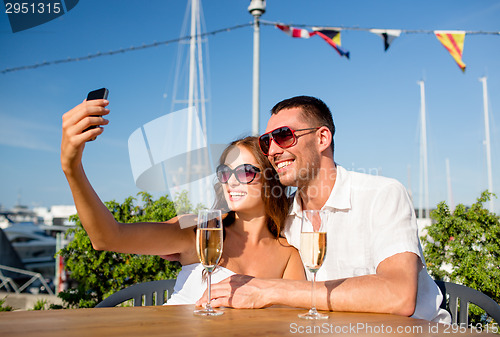 Image of smiling couple drinking champagne at cafe