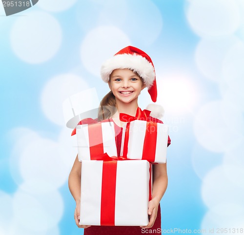 Image of smiling little girl in santa helper hat with gifts