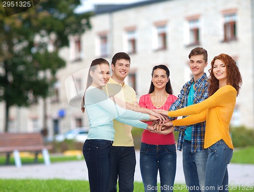 Image of group of smiling teenagers over campus background
