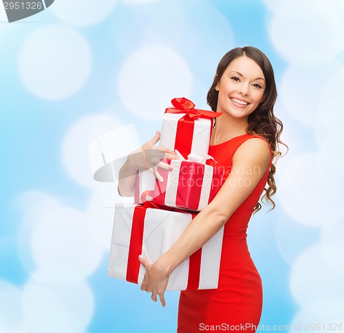 Image of smiling woman in red dress with gift boxes