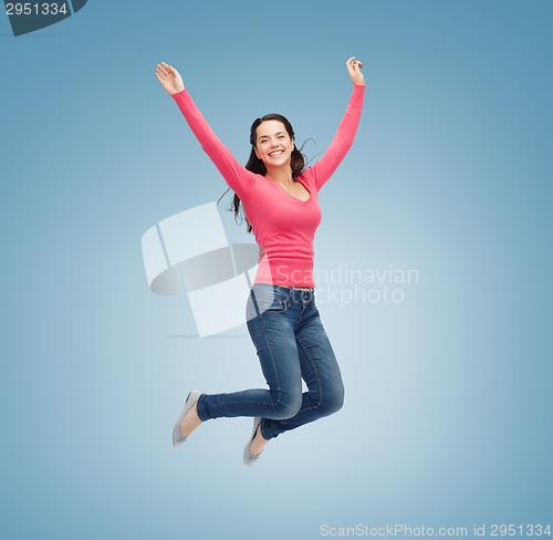 Image of smiling young woman jumping in air