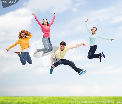 Image of group of smiling teenagers jumping in air