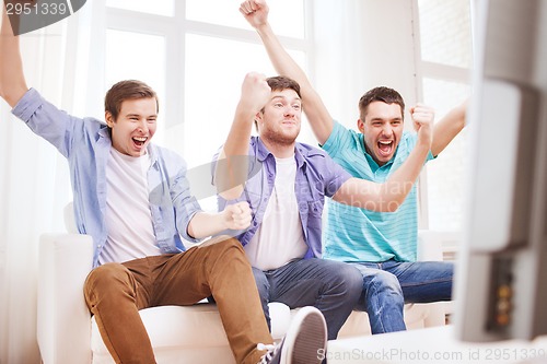 Image of happy male friends at home