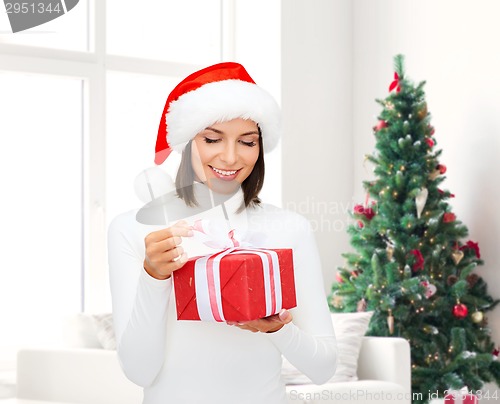 Image of smiling woman in santa helper hat with gift box