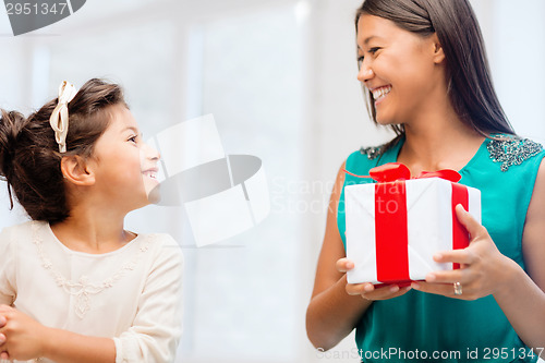 Image of happy mother and child girl with gift box