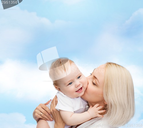 Image of happy mother kissing smiling baby