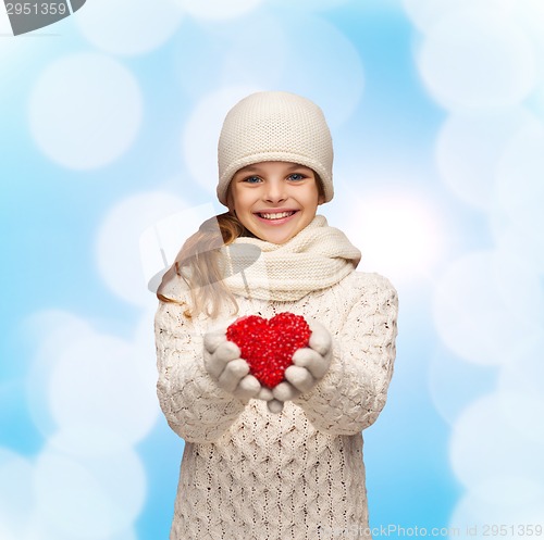 Image of dreaming girl in winter clothes with red heart