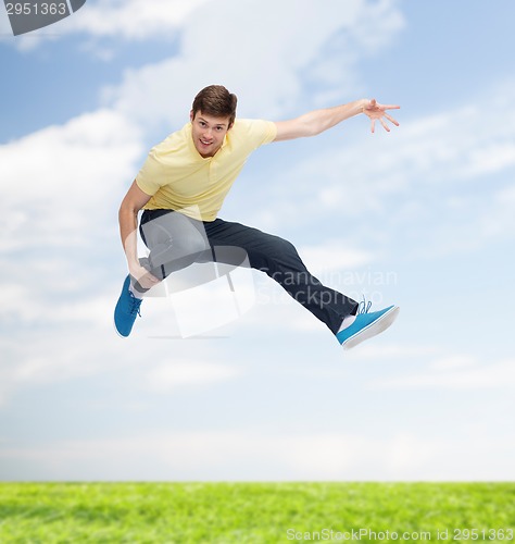 Image of smiling young man jumping in air