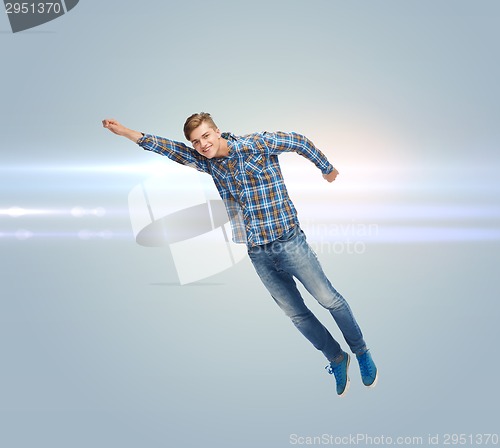 Image of smiling young man jumping in air