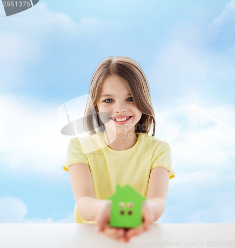 Image of beautiful little girl holding paper house cutout