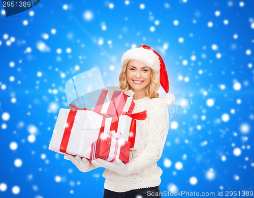 Image of smiling young woman in santa helper hat with gifts