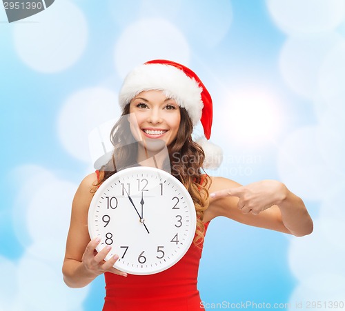 Image of smiling woman in santa helper hat with clock