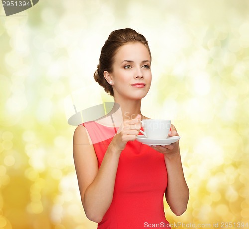 Image of smiling woman in red dress with cup of coffee