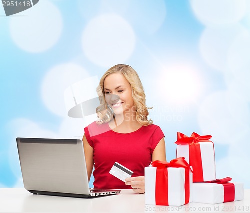 Image of smiling woman with credit card and laptop