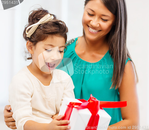 Image of happy mother and child girl with gift box