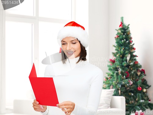 Image of smiling woman in santa hat with greeting card