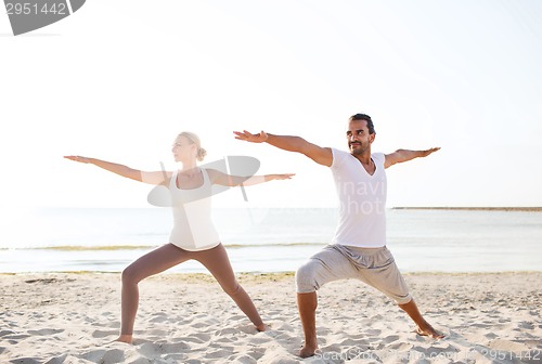 Image of couple making yoga exercises outdoors