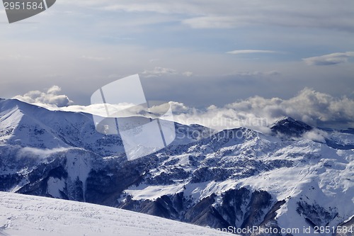 Image of Winter mountains in clouds and ski slope