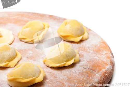 Image of Raw ravioli on wooden cutting board