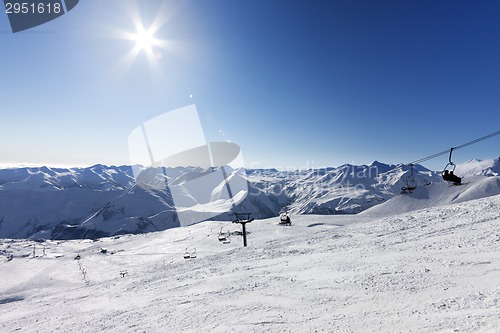Image of Ski slope and sky with sun