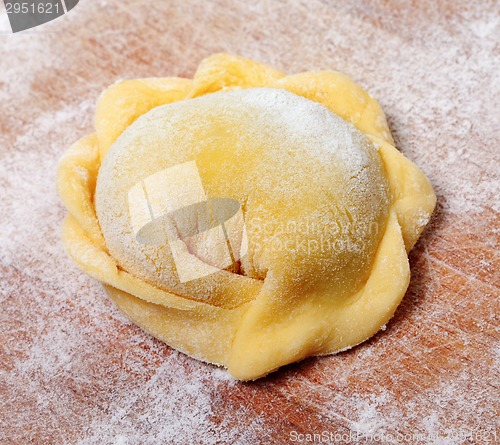 Image of Raw ravioli on wooden cutting board