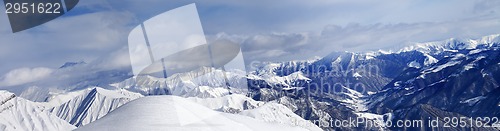 Image of Panorama of off-piste snowy slope and cloudy mountains