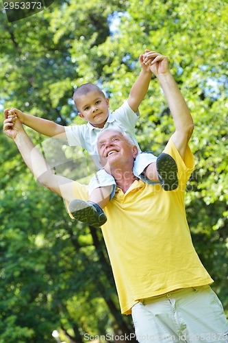 Image of happy grandfather and child in park