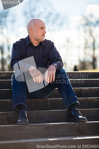 Image of Thoughtful man sitting on a flight of steps