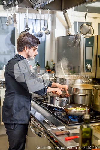 Image of Chef cooking a vegetables stir fry over a hob