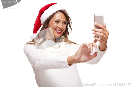 Image of Pretty woman in a Santa hat reading an sms