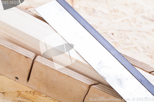 Image of Hand saw cutting through a beam of wood