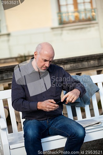 Image of Man checking a photo on his mobile phone