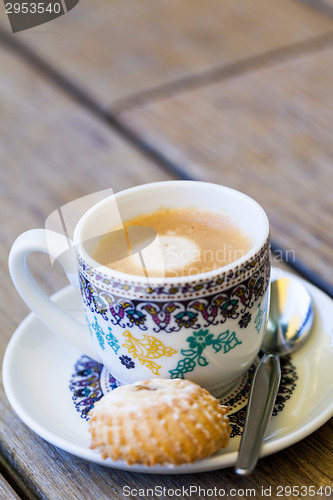 Image of Cup of freshly brewed tea and a cookie