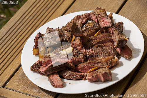 Image of Plate of Grilled Steak and Garlic with Red Napkin