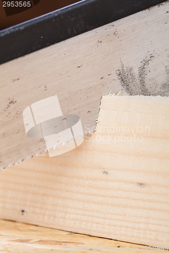 Image of Hand saw cutting through a beam of wood