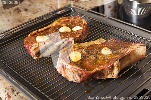 Image of Two Steaks Marinated with Oil and Garlic on Grill