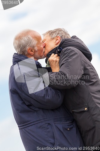 Image of happy elderly senior couple walking on beach