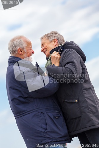 Image of happy elderly senior couple walking on beach