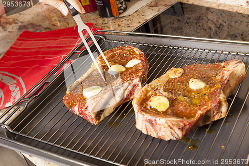 Image of Two Steaks Marinated with Oil and Garlic on Grill