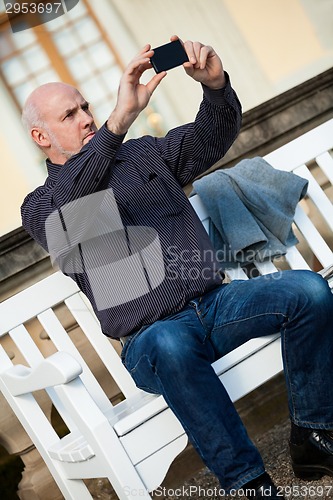 Image of Man taking a photograph with his mobile