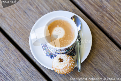 Image of Cup of freshly brewed tea and a cookie