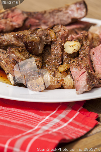 Image of Plate of Grilled Steak and Garlic with Red Napkin