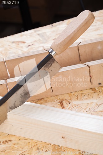 Image of Hand saw cutting through a beam of wood