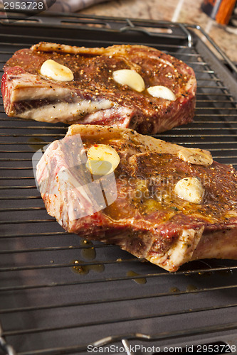 Image of Two Steaks Marinated with Oil and Garlic on Grill