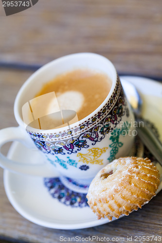 Image of Cup of freshly brewed tea and a cookie