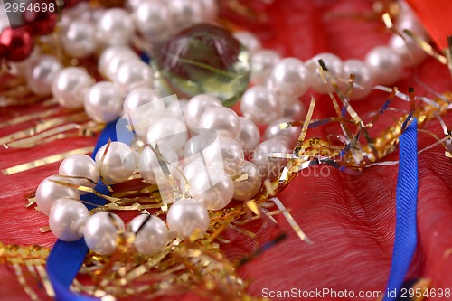Image of String of pearls on red background